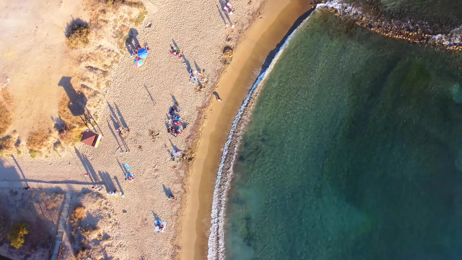 Playa urbana de San Juan de los Terreros con sombrillas, desde el aire